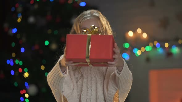 Cute Blond Girl Showing Christmas Gift to Camera, Miraculous Holiday Atmosphere