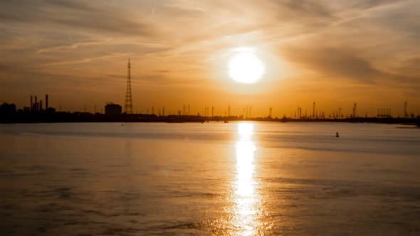 Antwerp International Port, dramatic timelapse at sunset with cargo ships passing.
