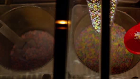 Top View Closeup Hand Takes Multicolored Candyballs in the Spoon