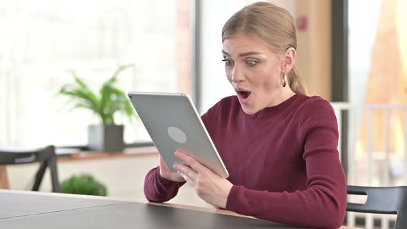 Success Young Woman Celebrating on Tablet in Office