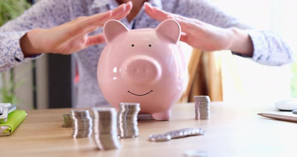 Business Woman Making Roof From Her Hands Over Piggy Bank with Coins Closeup  Movie