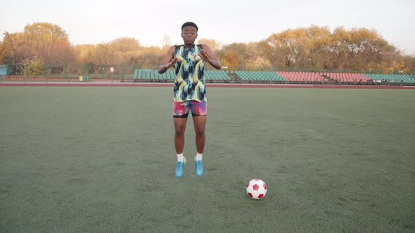 Young African American Woman Playing Sports at City Stadium During Soccer Team Training and Jumping