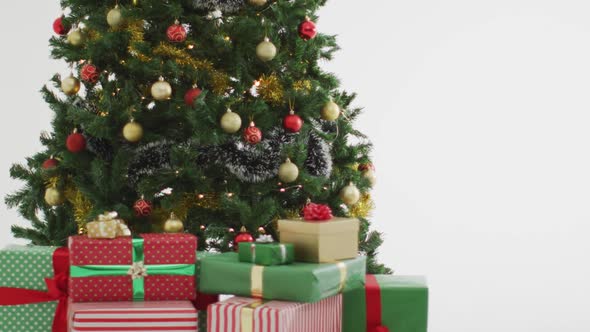 Video of christmas tree decorated with baubles on white background