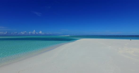 Daytime overhead tourism shot of a white sand paradise beach and aqua turquoise water background in 