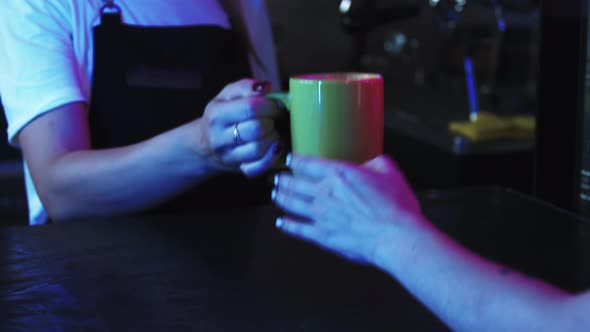 Barista Serving a Cup of Coffee to Her Client