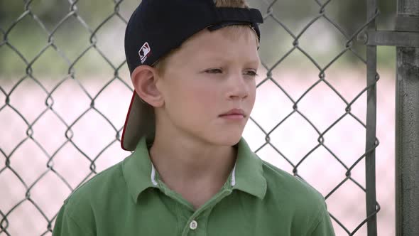 Slow motion of boy hitting baseball mitt as he turns and smiles.