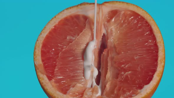 Closeup of a Half of a Grapefruit Sticky White Liquid Pouring Onto It