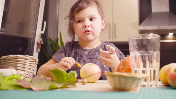 Little Girl Makes Necklace of Acorns