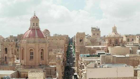 Beautiful Church Towers with Red and Beige Rooftops Above the City of Valletta, Malta, Aerial Dolly