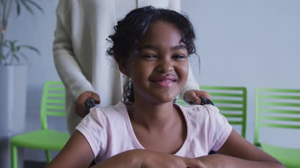 African american girl smiling while sitting on a wheelchair at hospital