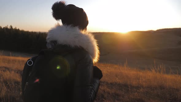 Woman Traveler with Backpack Hiking in Mountains at Sunset. Silhouette Hiker Walking, Freedom