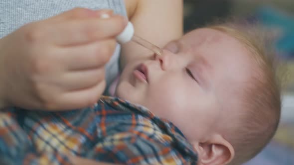 Mommy Gives Cure From Snuffle To Baby with Pipette in Room