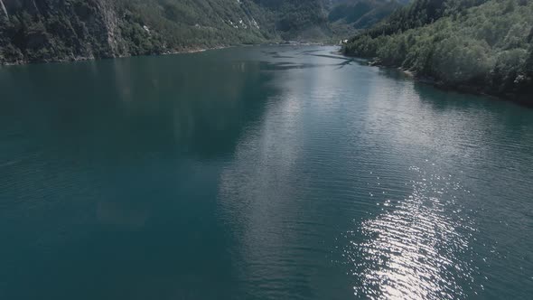 Blue lake water of Tafjord area in Norway, aerial FPV drone view