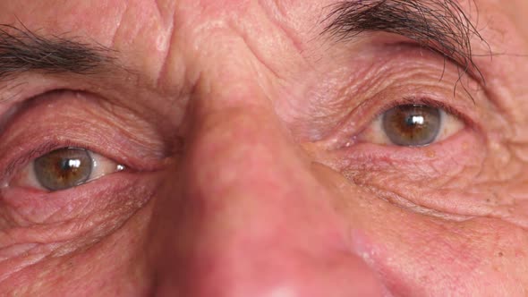 Close-up of the eye of a caucasian elderly man over 70 years old. Positive view of the pensioner. Re