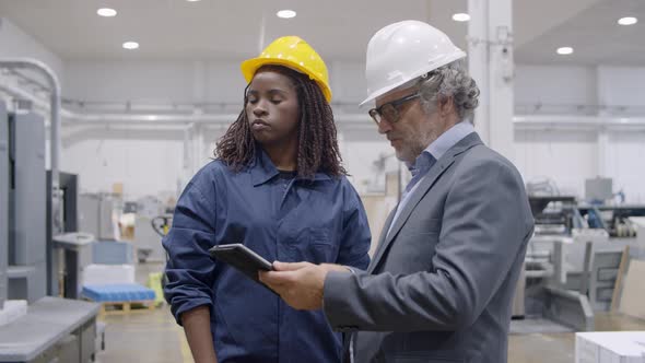 Male Engineer Instructing Black Female Factory Worker