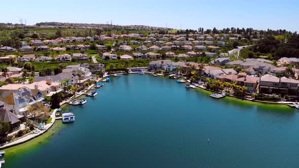 Aerial drone flying into houses in a cove on community lake mission viejo