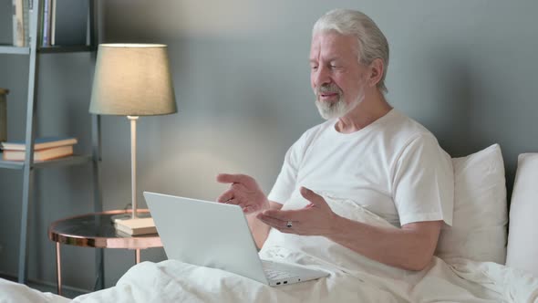 Online Video Call on Laptop By Old Man in Bed 