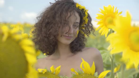 Portrait of Confident Beautiful Curly Girl Looking at the Camera Smiling Standing in the Sunflower