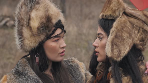 close-up of two loving asian young women in ethnic clothes looking at each other