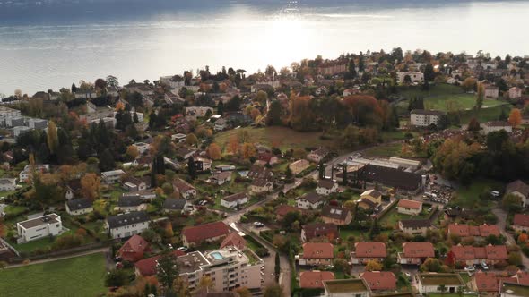 Tilt up from small town to beautiful mountain scape at Lake Geneva