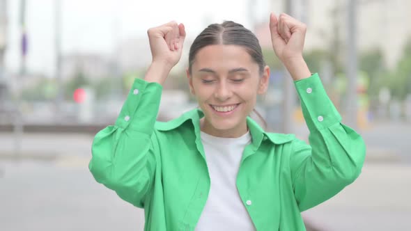 Excited Hispanic Woman Dancing and Smiling Outdoor