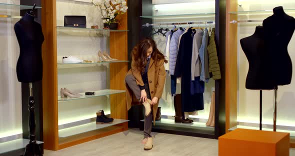 Cute Girl with Long Hair Tries on Shoes To Her Image in a Clothing Store