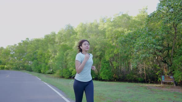 Asian cute girl She was jogging in the morning in the garden and the sun was shining, 4k resolution.