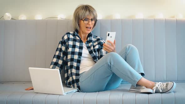 A Beautiful Grayhaired Middleaged Woman with Someone is Having Fun Talking and Laughing on the Phone