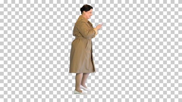 Mature lady in a trench coat walking and, Alpha Channel