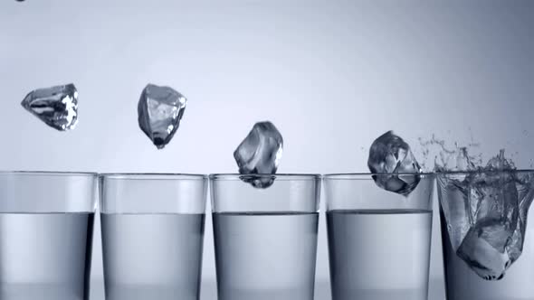 Slo-motion ice cubes falling into glass