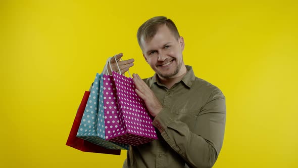 Joyful Man Showing Black Friday Inscription From Shopping Bags, Smiling Satisfied with Low Prices