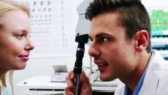 Close-up of optometrist looking through ophthalmoscope