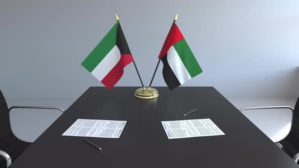 Flags of Kuwait and the UAE and Papers on the Table