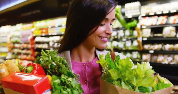 Woman holding grocery bag in grocery section