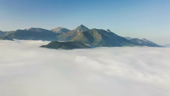 Aerial Flight above Clouds in Mountains in Autumn Morning Landscape