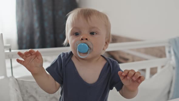 Toddler with Pacifier in Crib