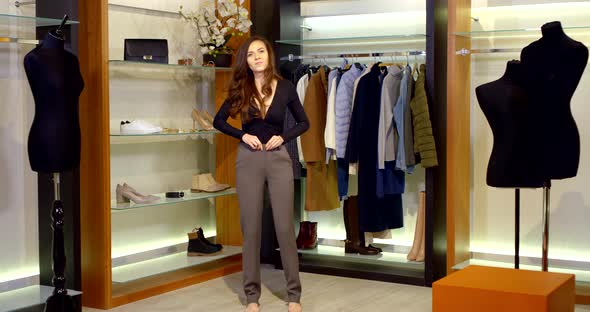 Young Brunette Woman Is Trying Pants in Wardrobe Room in Apartment, Fastening Zipper