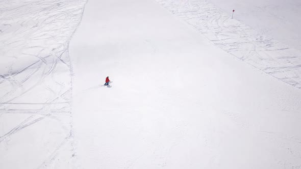 4k aerial footage, drone following skiers on ski slope in skiing region. Skiers skiing downhill the