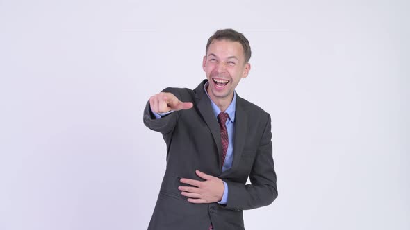 Studio Shot of Happy Businessman Laughing and Pointing Finger