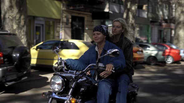 Two Young Women Enjoying Riding Motorcycle By the City Street on the Summer