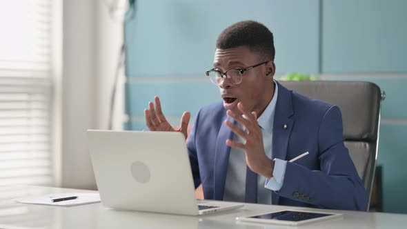 Young African Businessman Reacting to Loss While Using Laptop