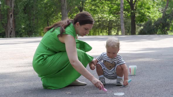 Mother and Little Child Having Fun Drawing on Asphalt in Summer Park Toddler Boy Playing with