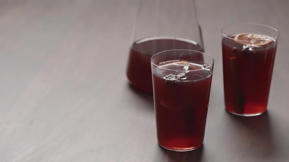 Slow Motion Man Hand Take Mulled Wine in Thin Tumbler Glass From Walnut Table