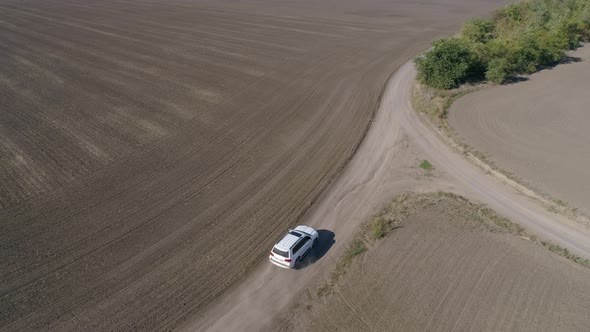 Car Rides on Road Between Fields with Cultivated Soil in Fall