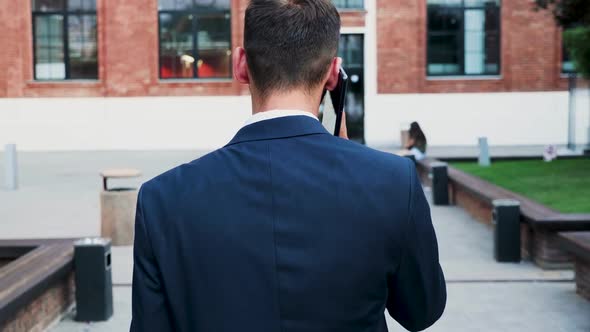 Back View of Businessman Having on Conversation on the Phone, Slow Motion