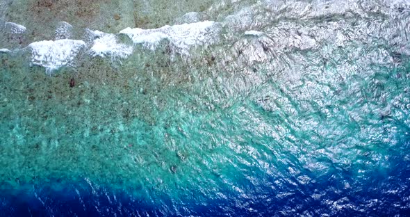 Tropical flying clean view of a white sandy paradise beach and aqua turquoise water background in be