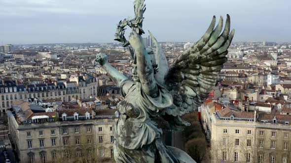 Close up of Liberty Angel Girondins monument in Bordeaux, France, with city panorama and Garonne riv