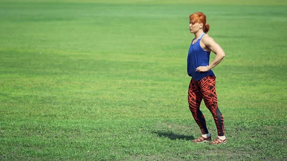 Young Woman Doing Exercise on Grass in the Park
