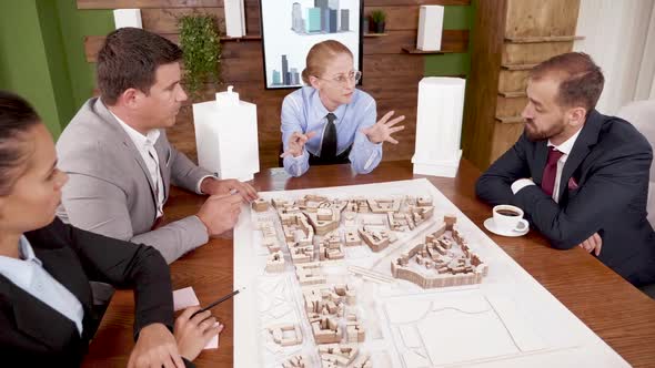 Female Architect Explaning Her Real Estate Project To Young Investors