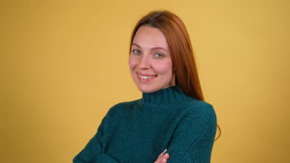 Studio Portrait of Confident Smiling Young Woman Laughing Against Yellow Background